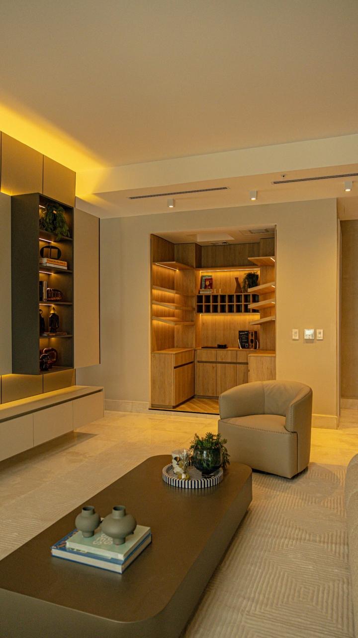Cava de vinos en madera con iluminación indirecta junto a la sala — Ocean Reef