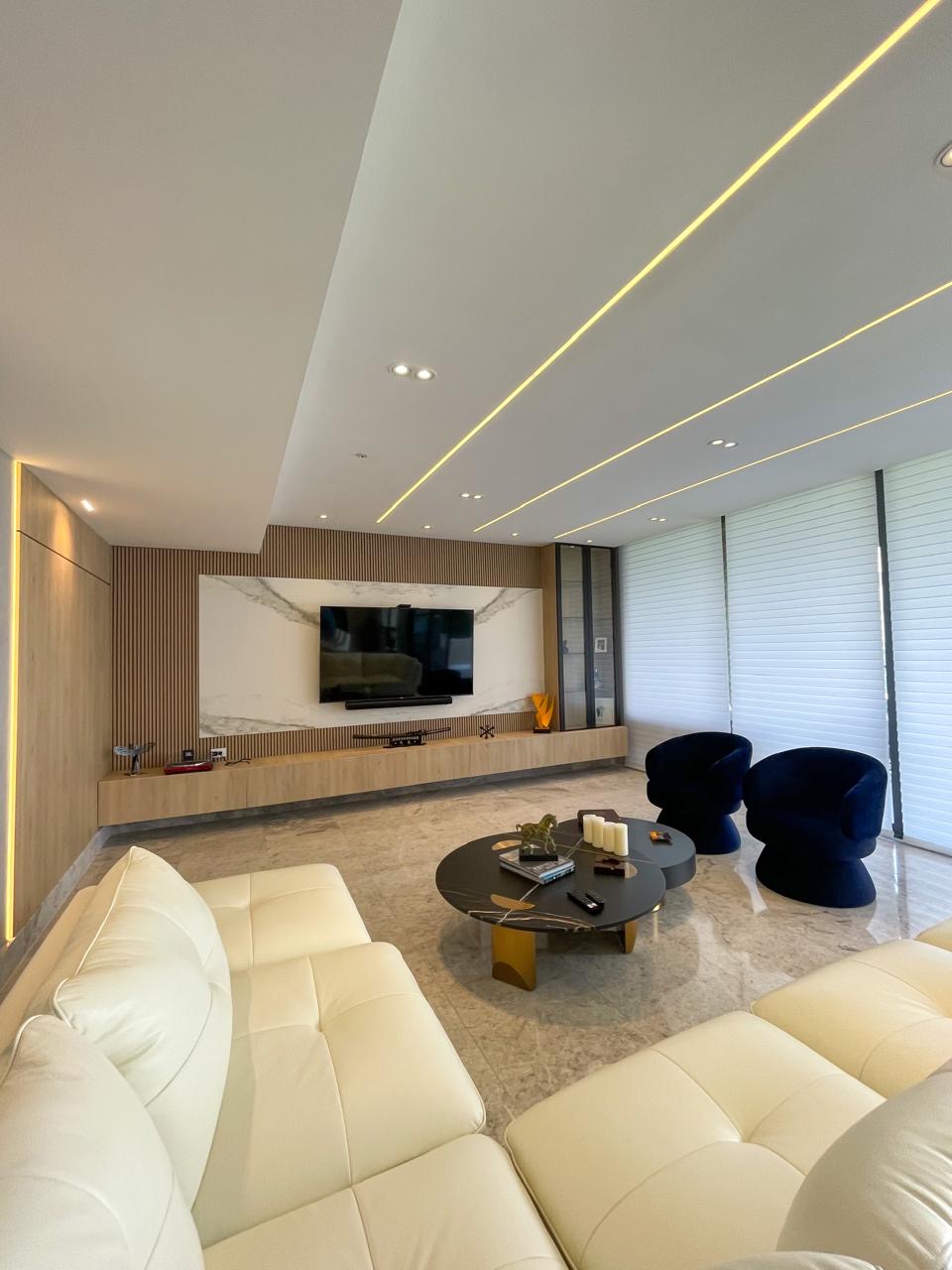 Angled view of the living room with marble panel and swivel armchairs — PH Empire