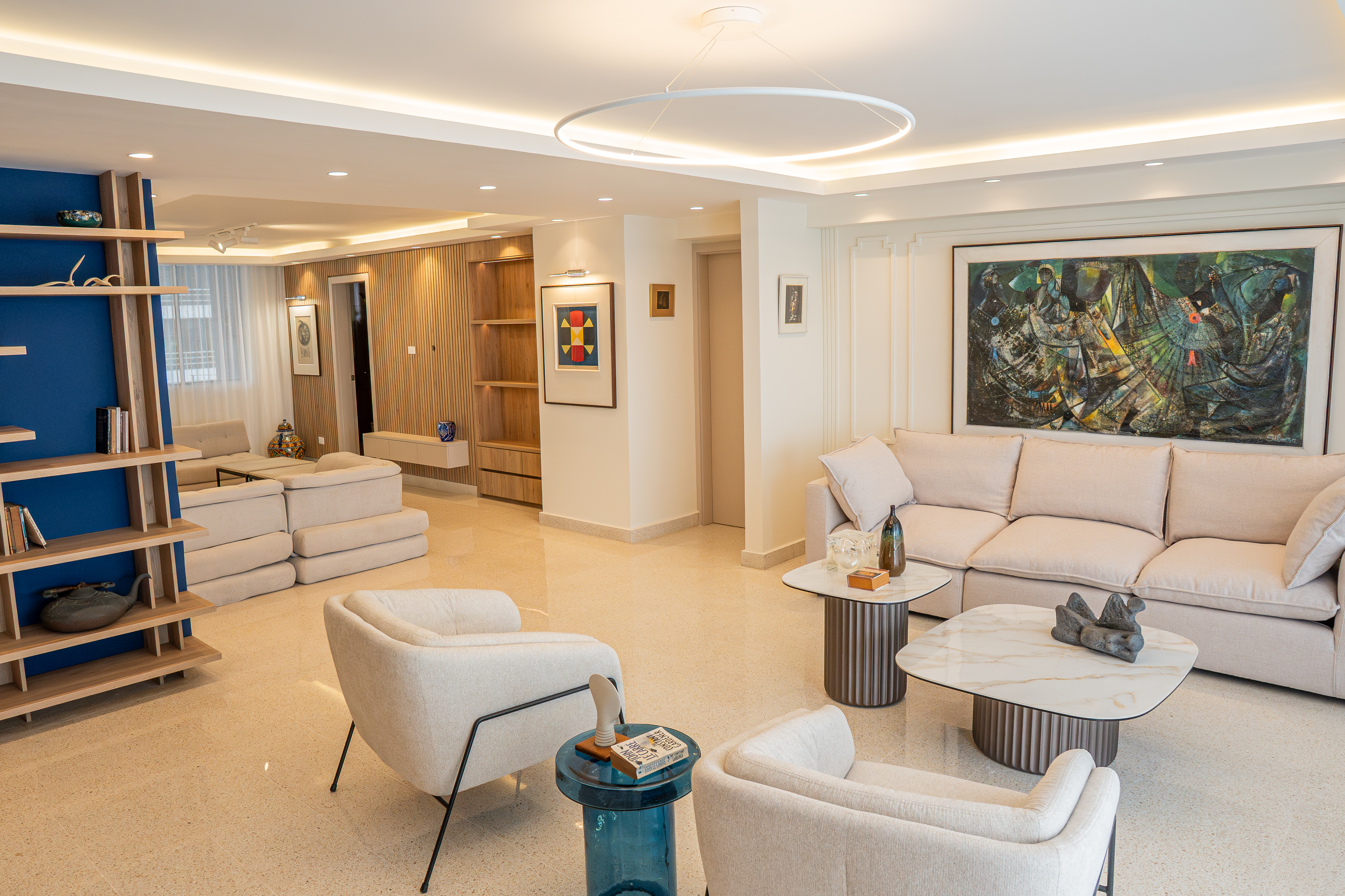 Sala abierta con pared azul y estantería de madera — PH Torre del Mar