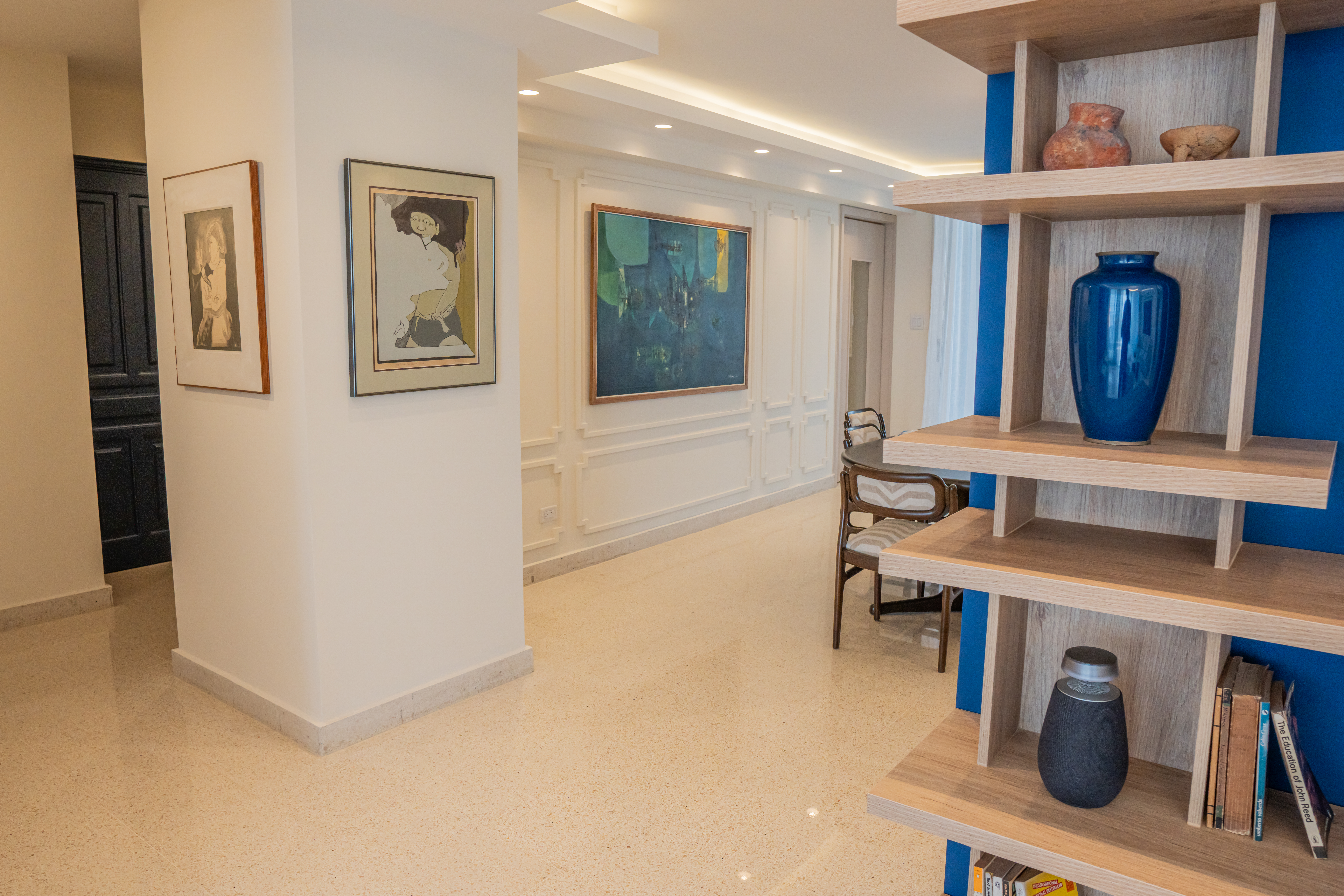 Estantería de madera sobre pared azul con piezas decorativas — PH Torre del Mar