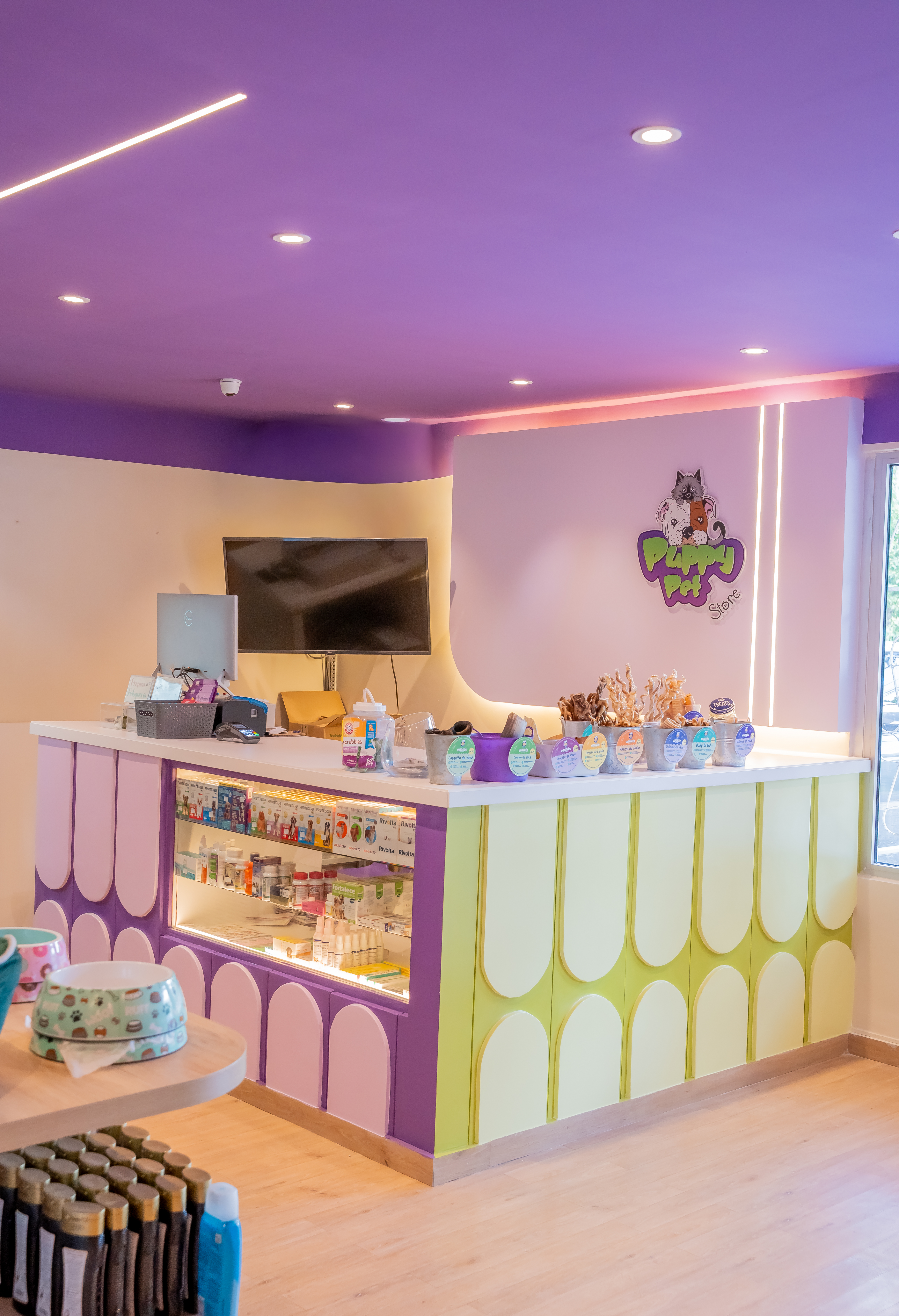 Checkout counter with display case and brand signage — Puppys Pet Store
